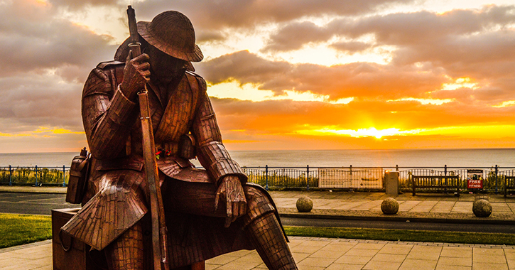 1101 - sculpture of a world war two soldier with sun set and sea in background